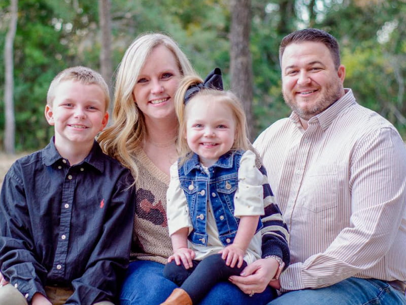 Halle Spivey survived after her heart stopped for 27 minutes, and today she is thriving. Pictured from left: brother Charlie, Halle, mom Autumn, and dad Britt Spivey. (Photo by Theresa Bluhm Photography)