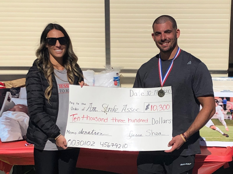Stroke survivor Jesse Shea (right) and his sister, Alex, hold a check for the American Stroke Association raised in a half-marathon. (Photo courtesy of Jesse Shea)