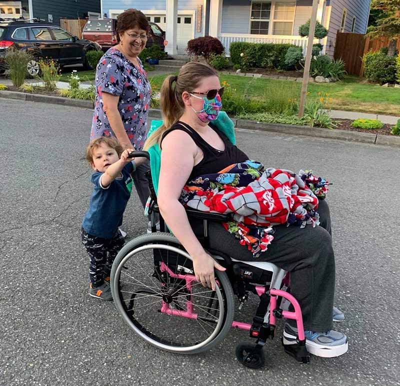 Kristy Novillo is pushed in her wheelchair by Dominic as their family nanny accompanies them on an evening stroll. (Photo courtesy of Jorge Novillo)
