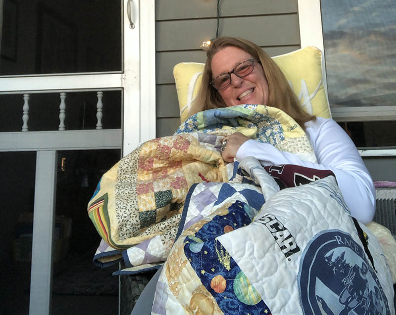 Liz Hindinger with the quilt her aunt made using fabrics donated by family and friends during Liz's recovery.(Photo courtesy of Elizabeth Hindinger)