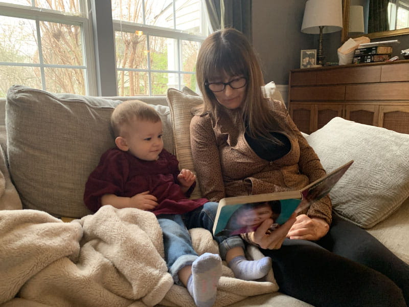 Kate Adamson reading to her granddaughter, Nora. (Photo courtesy of Kate Adamson)