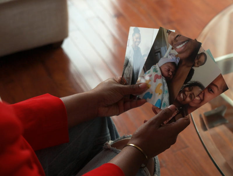 Marian Dancy holding photos of she and her children. (American Heart Association)