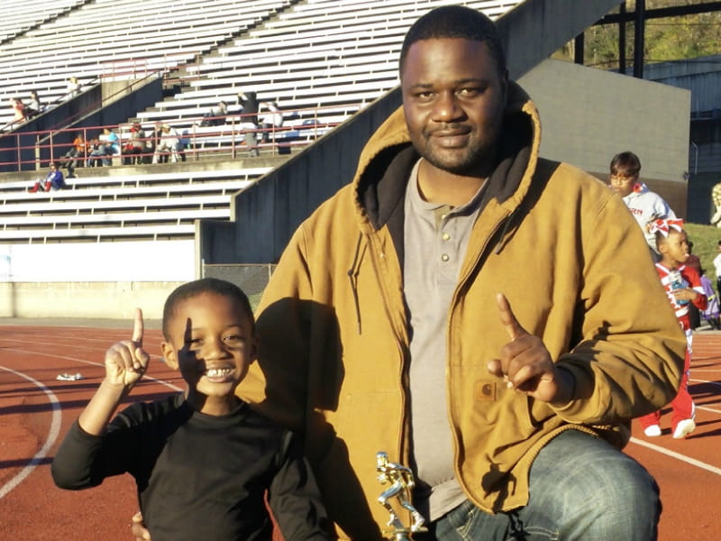 Brian Keith (right) celebrates his son Jahari's first football championship. (Photo courtesy of LaKeisha Barron-Brown)