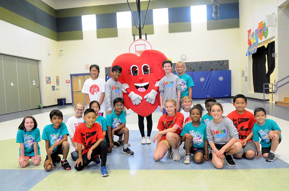 GO Heart Mascot with group of students in school gym