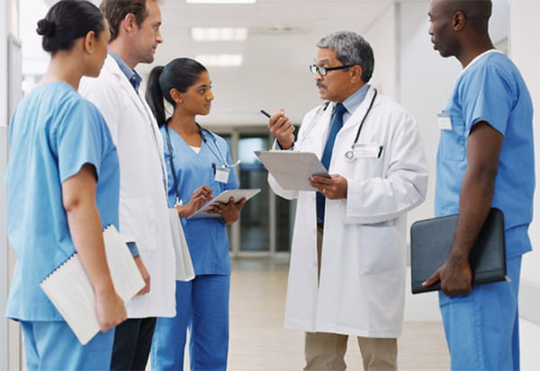 diverse team of healthcare workers gather in hospital discussing work together