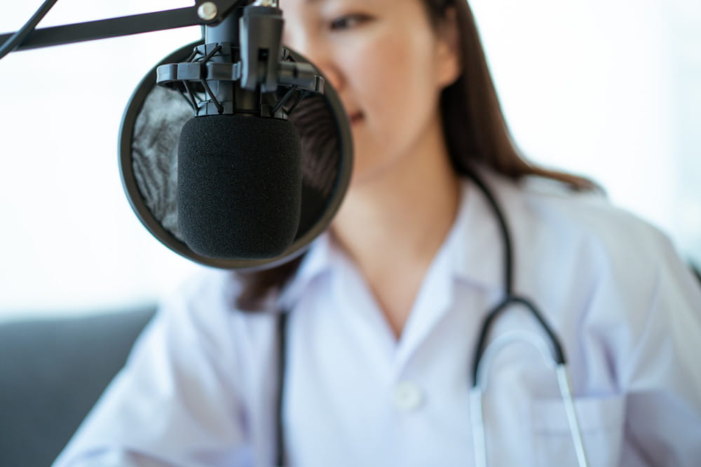 Doctor speaking into a podcasting mic