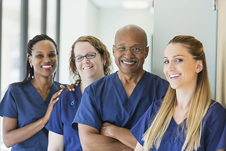 four medical workers smiling at camera
