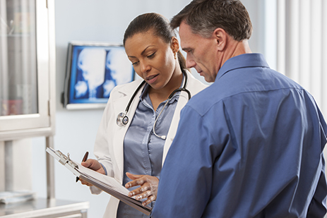 female doctor going over medical chart with male patient