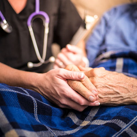 Patient and caregiver holding hands