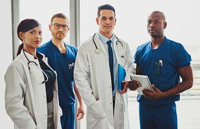 one female doctor, one male doctor, and two male medical workers posing for camera