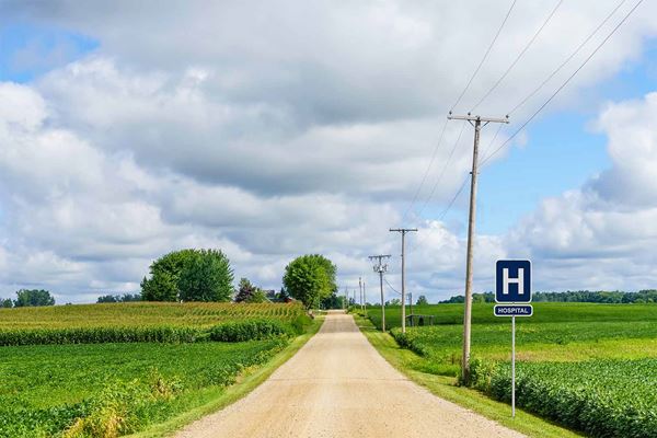 Image of a country road with road sign saying "Hospital"