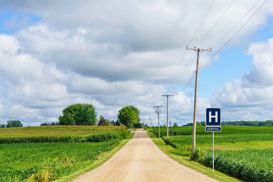 Image of a country road with road sign saying "Hospital"