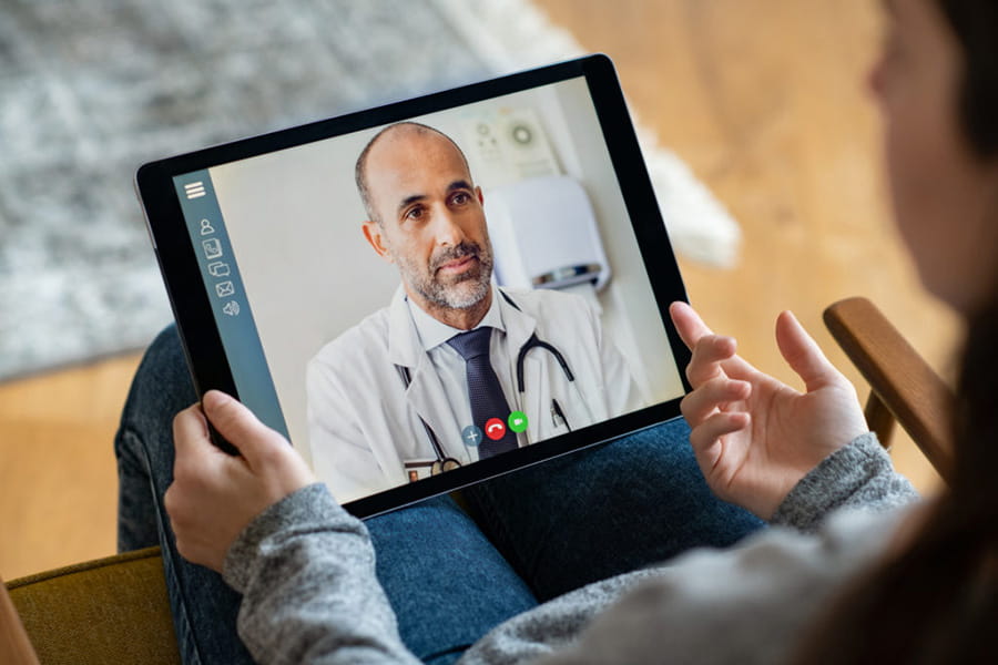 woman at home teleconferencing with healthcare professional