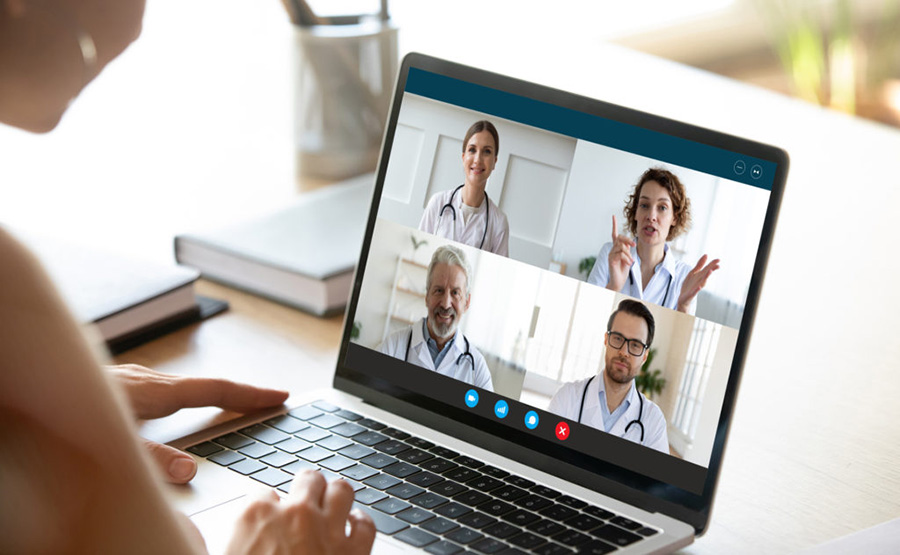 Woman at home interacting with four health professionals via video conference