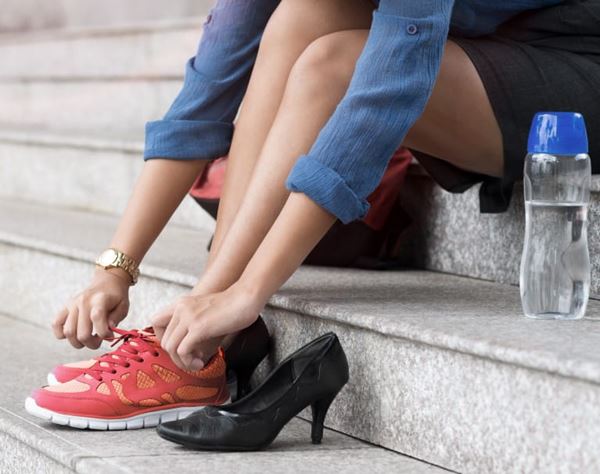woman putting on tennis shoes