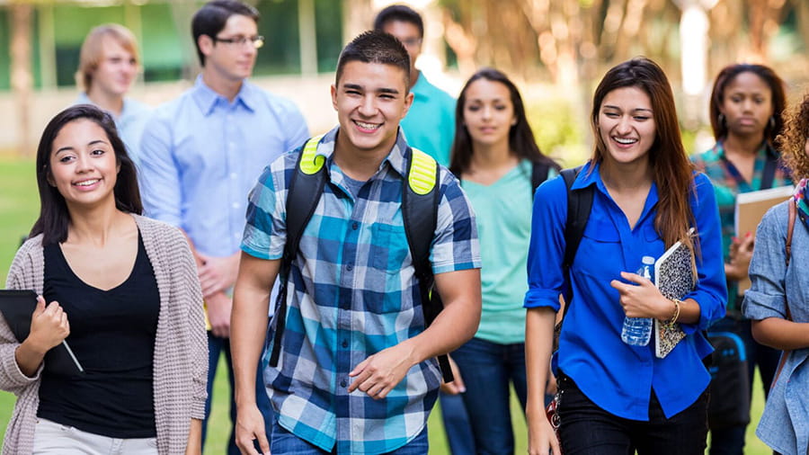 multicultural group of teens walking from class