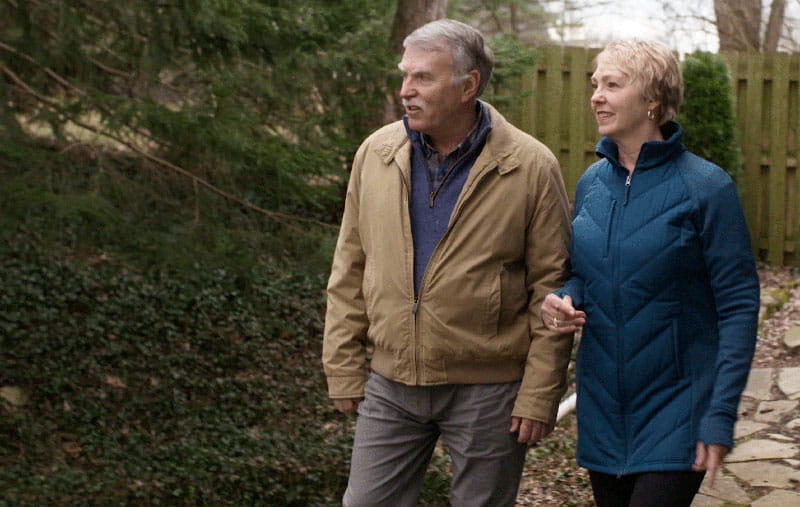 Gail Hogan and her husband walk outdoors