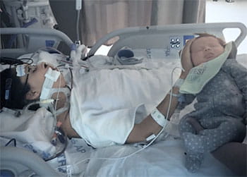 Jen Rohe, heart disease survivor in hospital bed postpartum