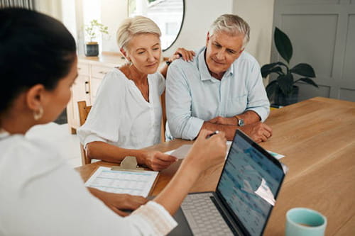 Older couple sitting with financial planner at a table