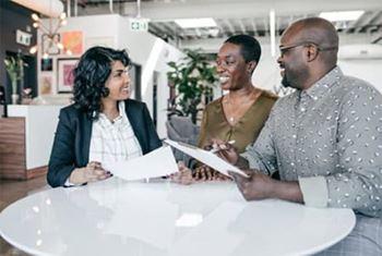 Advisor and smiling couple discussing estate plans and options