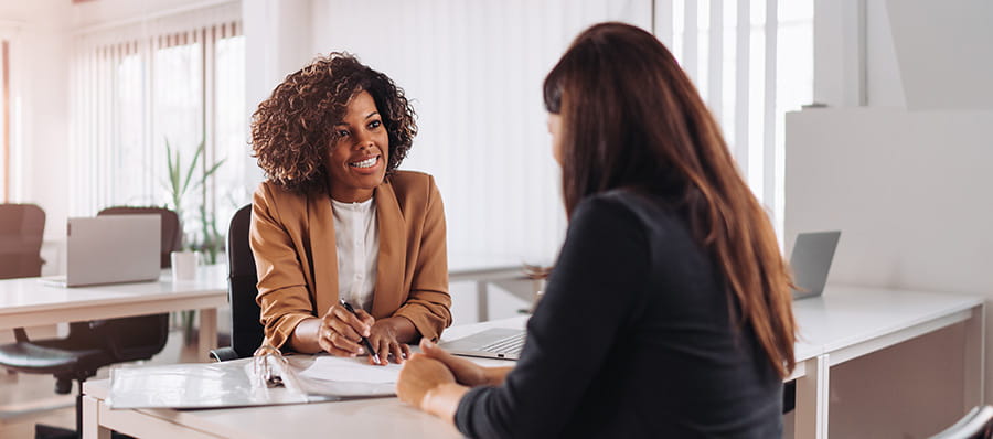 Smiling trustee or attorney talking with client in office