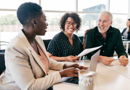 A couple discussing financial options with an advisor in a bright lit public area