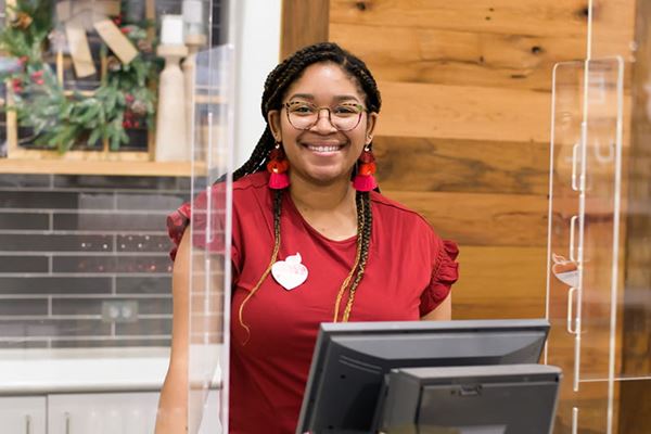 Smiling Kirkland's employee at register