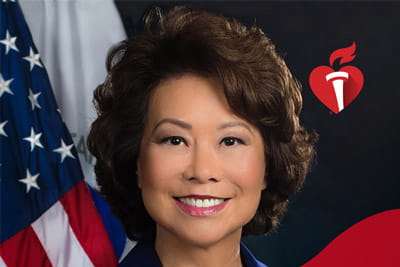 a portrait of Elaine Chao with the United States flag in the background