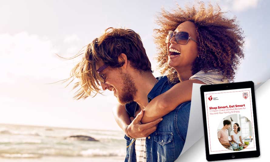 young happy woman and man on the beach - woman with arms around man's neck