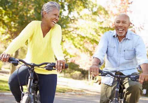 middle aged smiling woman and man riding bicycles