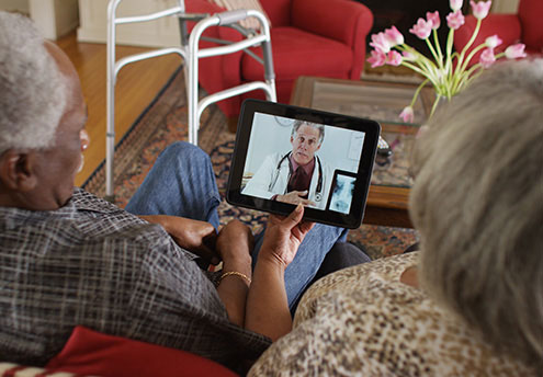 elderly couple looking at ipad
