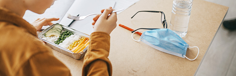 boy with mask eating school lunch boy with mask eating school lunch