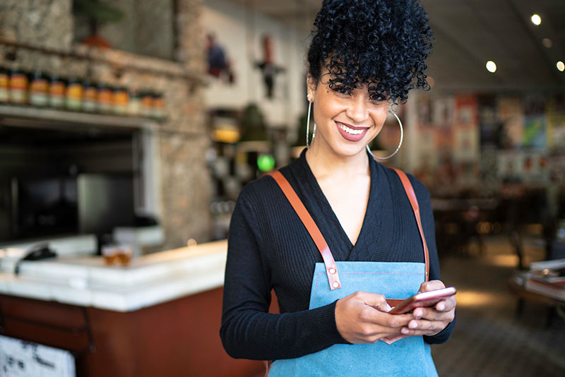 woman restaurant worker uses cell phone woman restaurant worker uses cell phone