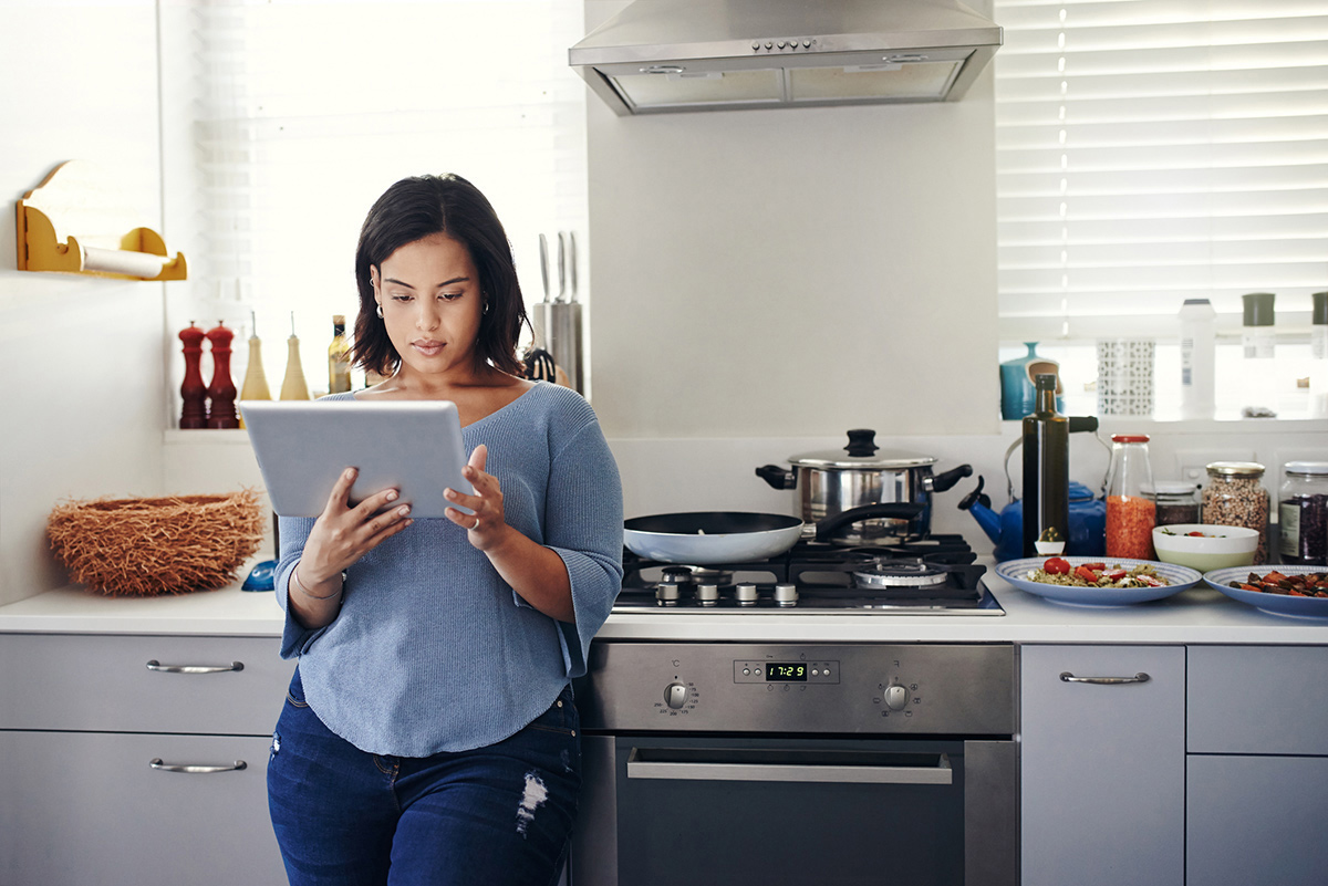 woman using tablet in kitchen woman using tablet in kitchen