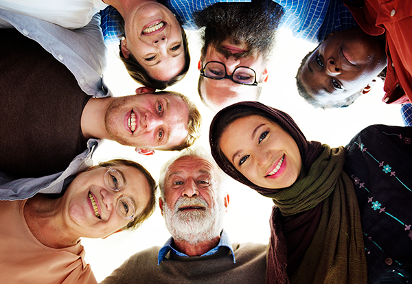 diverse group of people in circle looking down at camera