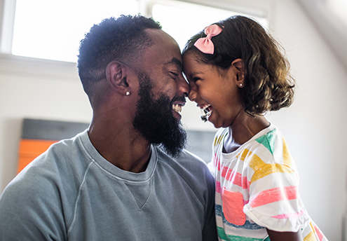 father and daughter forehead to forehead smiling and laughing