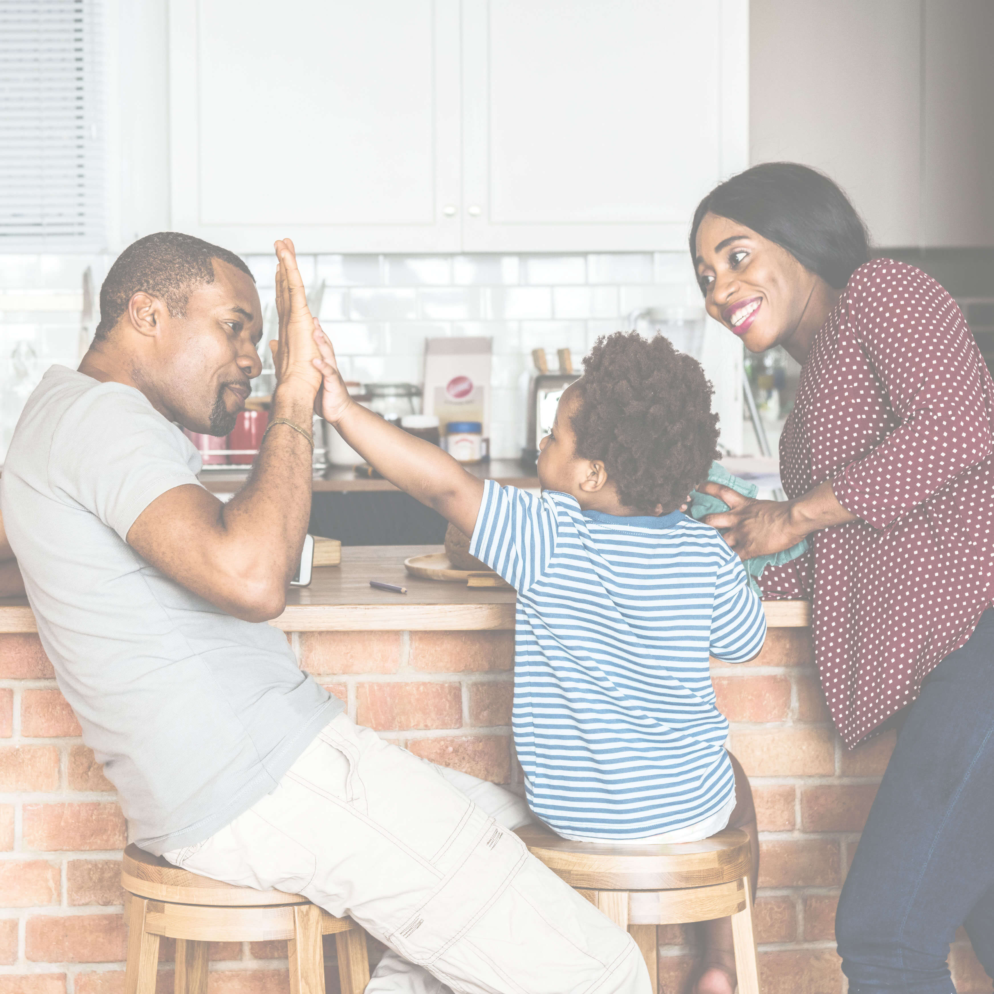 African-American family (father, mother and son) gathered around kitchen island