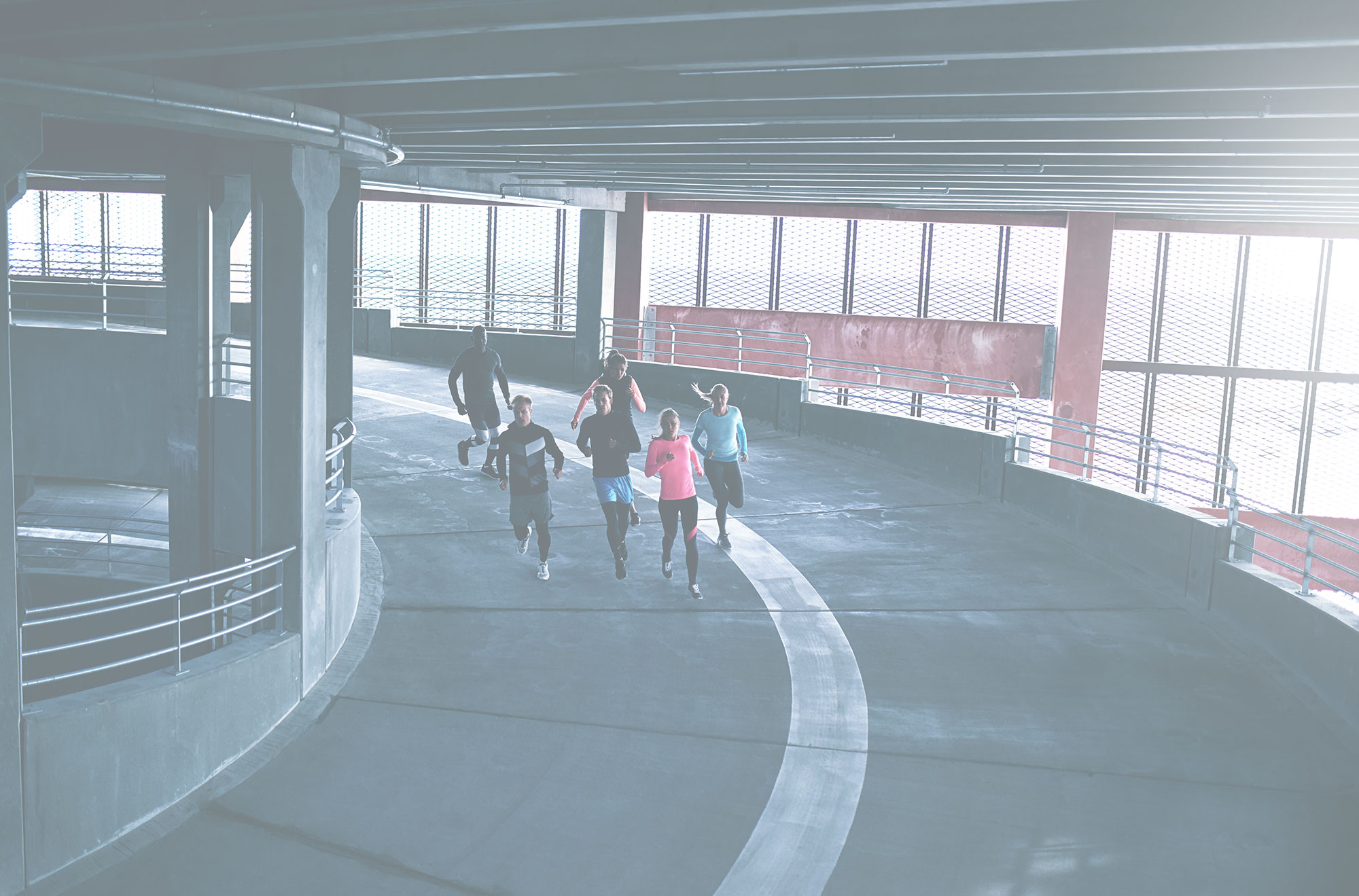 People running in a parking garage