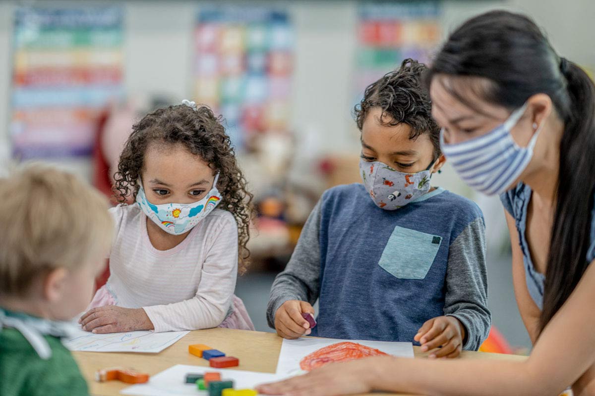 children and teacher wearing masks