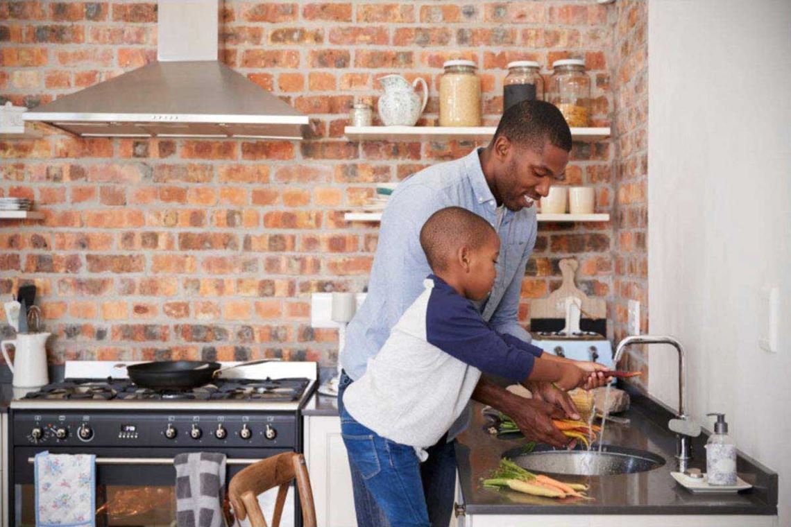 father and son cooking in modern kitchen