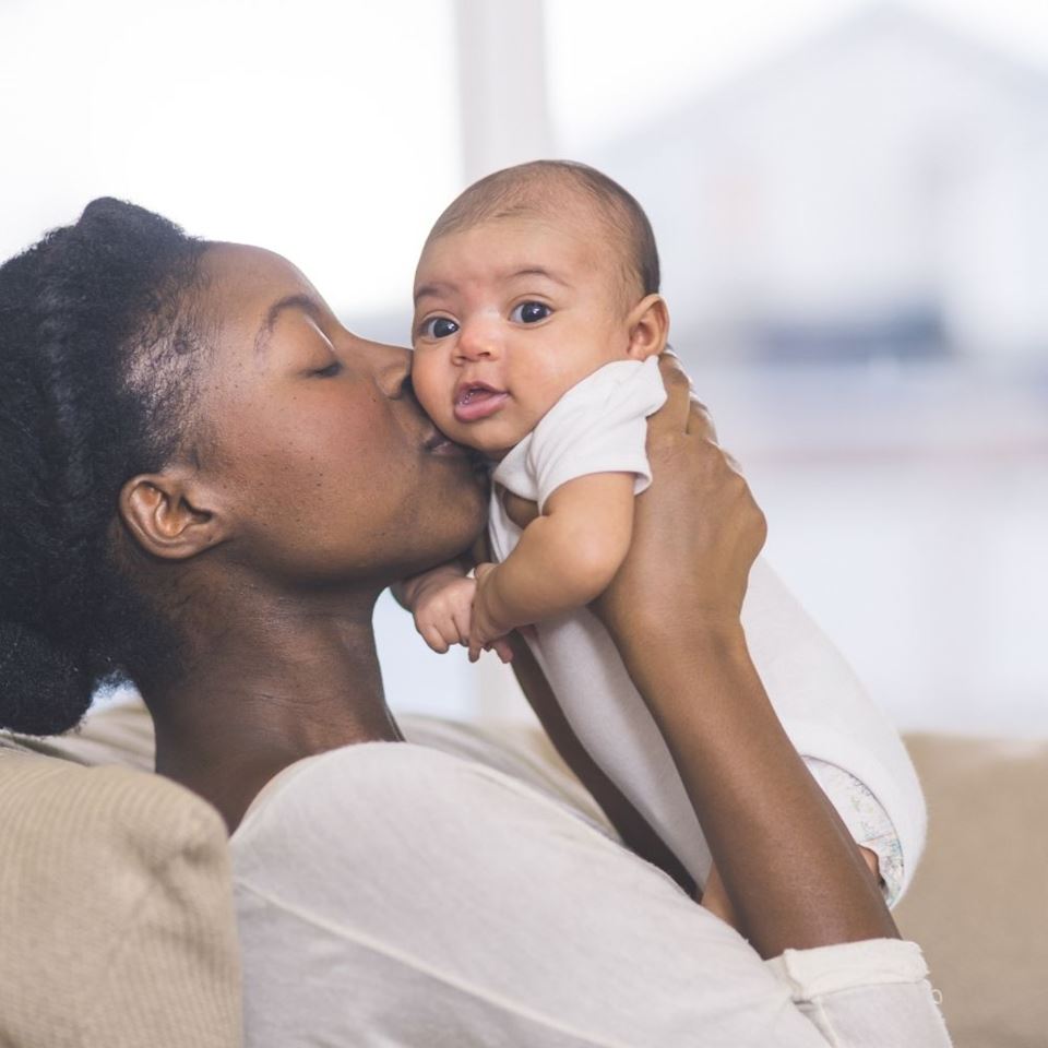 woman kissing infant