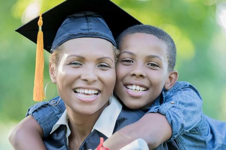 woman wearing graduate cap with boy hugging her