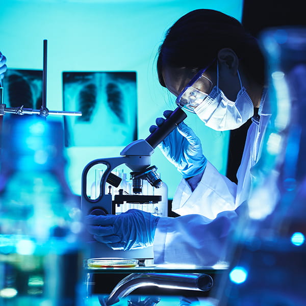 Scientist peering into microscope