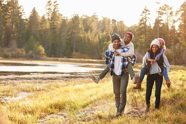 family hiking with kids piggy backing
