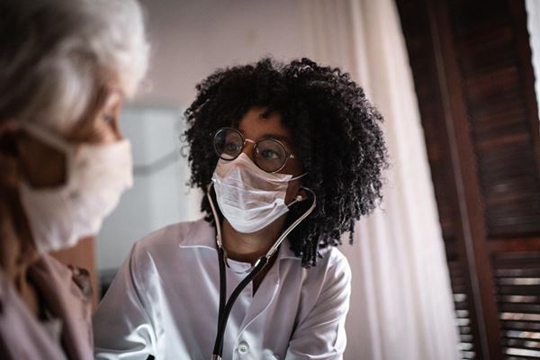 medical professional in mask treating patient