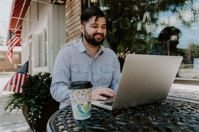 man sitting at coffee table viewing laptop