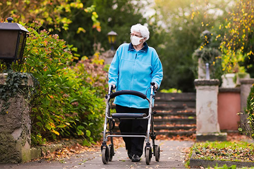 woman outside with walker wearing mask