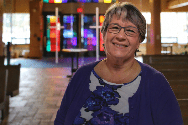 A woman standing in a church smiling