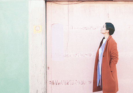 woman in oakland standing by colorful wall looking up