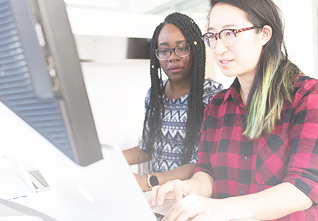 two women working together on a computer